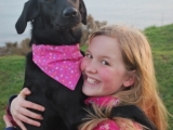 Maggie, on her first birthday, enjoying a cuddle with Katherine.